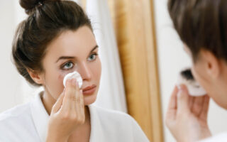 Mujer en un espejo quitando maquillaje