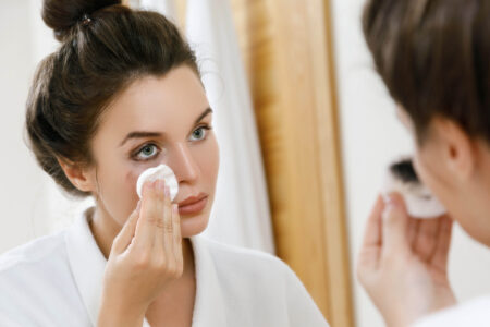 Mujer en un espejo quitando maquillaje